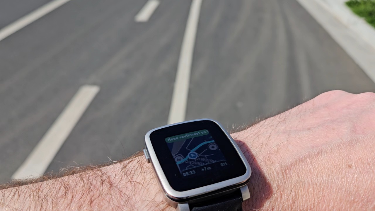 MirrorMap showing a next-turn instruction and ETA on a Pebble, dark map theme